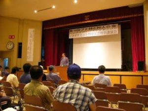 写真2．記念講演会の様子。朝日村村長の開会挨拶。